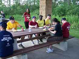 players eating hot dogs at picnic table
